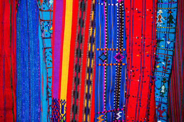 Colorful textile for sale in public space in Guatemala City, work done by indigenous hands of millenary Mayan culture, handicraft work economy in Latin America. - 620626424
