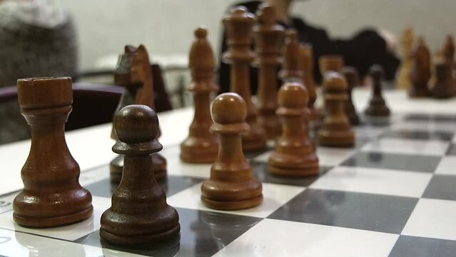 Close-up brown chess pieces on a chessboard	
