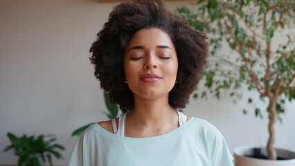 Handsome african curly haired woman breathing and looking at camera at home. Healthy lifestyle. Sport - Powered by Adobe