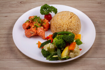 chicken tikka Quinoa in white plate on wooden background