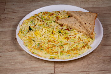 Keto Omelette With Cheese in white plate on wooden background
