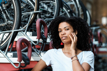 Fototapeta na wymiar Curly woman posing in front of bike rack.