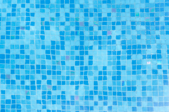 detalle de agua limpia en alberca con fondo del suelo de mosaico de cuadros azules