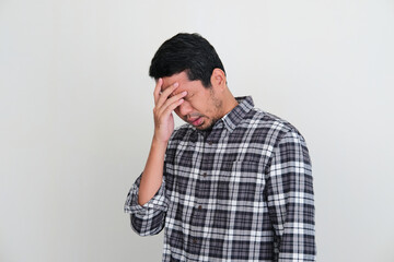 Adult Asian man with head down showing stress expression