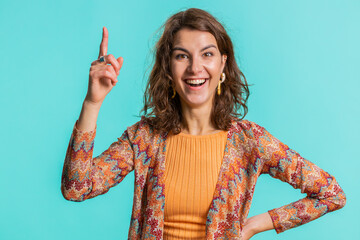 Eureka. Inspired young woman pointing finger up with open mouth, having good idea plan startup, showing inspiration motivation gesture, problem solution. Pretty girl isolated on blue background