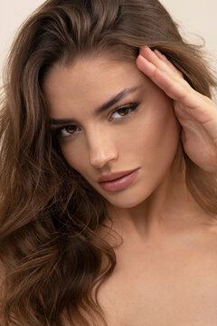 Sensual photo shoot of beauty brunette on creamy background.