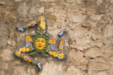 typical trinacria signs on a stone facade in Taormina, Sicily, Italy