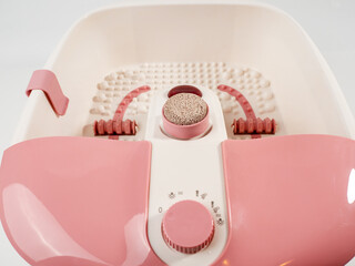 Vibrating foot massager on a white background. Foot bath close-up.