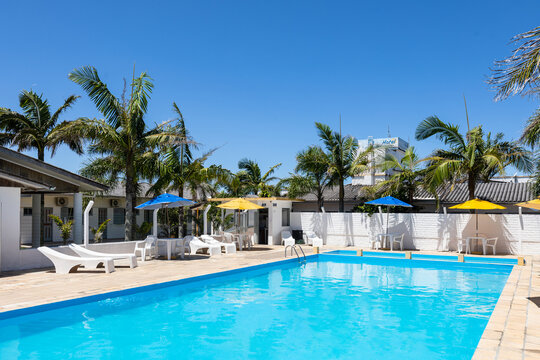 Swimming pool and lounge area with hammocks, tables and beach umbrella