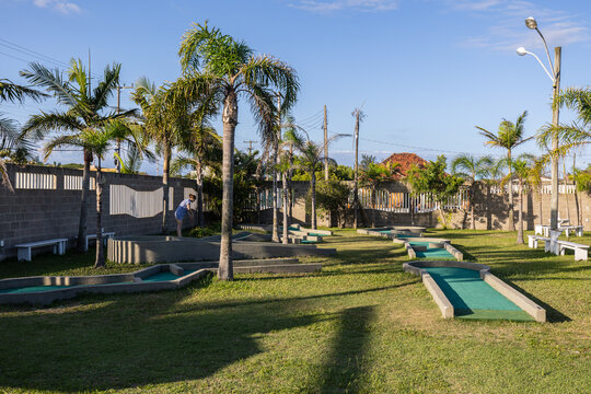 Courtyard of a vintage hotel with a mini golf course and palm trees