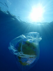 globe earth world in plastic bag underwater  ocean pollution