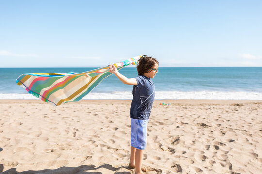 Boy holding towel at the beach