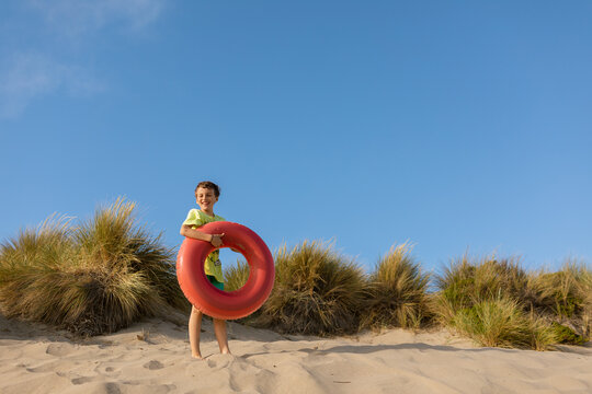 Boy on dunes with donut floaty