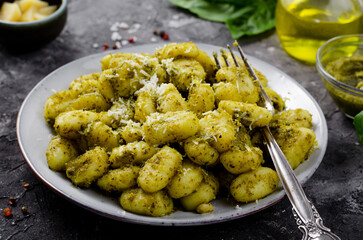 Gnocchi with Pesto, Potato Gnocchi Tossed with Basil Pesto Sauce, Italian Cuisine, Tasty Meal over Dark Background