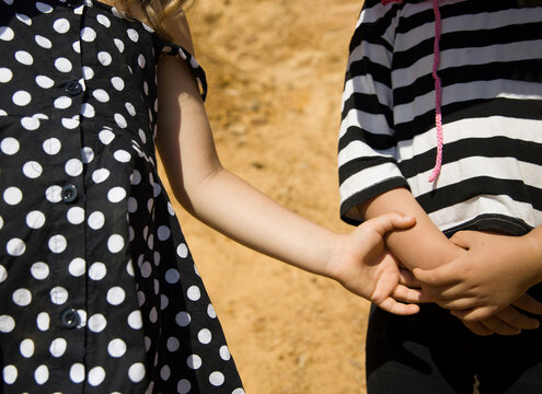 Close up image of a two  kids holding hands 