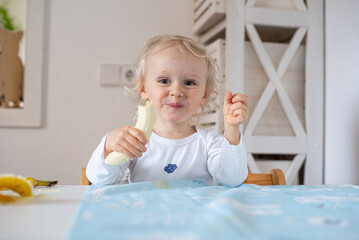 little child happy eating banana