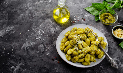 Gnocchi with Pesto, Potato Gnocchi Tossed with Basil Pesto Sauce, Italian Cuisine, Tasty Meal over Dark Background