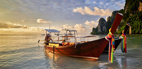 koh phi phi thailand with long tail boats on beach at sunrise - 620655843