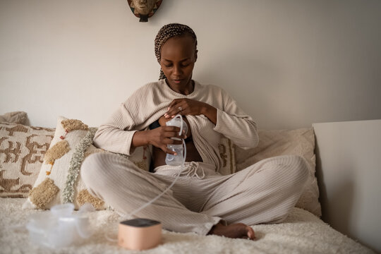 Mother pumping milk into bottle for baby