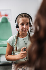 Audiologist doing impedance audiometry or diagnosis of hearing impairment. An beautiful teenage...