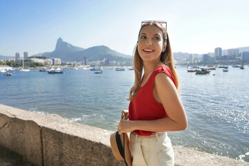 Portrait of stylish tourist girl on famous Mureta da Urca short wall along Rio de Janeiro promenade...