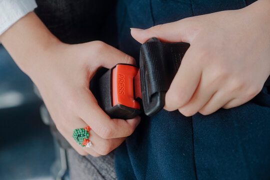 A girl fastens her seat belt 