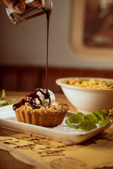 apple pie with vanilla ice cream and chocolate dripping from top