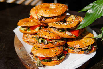 Fresh bagels with vegetables and champignons on rustic wooden board. Snacks for parties and picnics. Catering service.