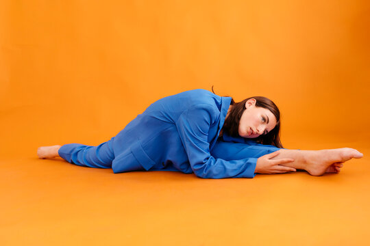 Flexible woman stretching in split and bending forward