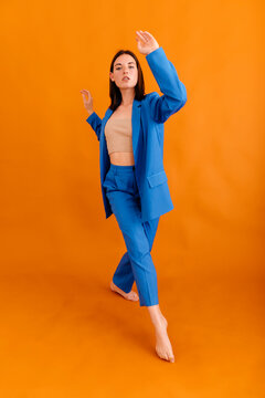 Young woman with raised arms standing in yellow room
