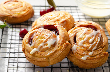 Freshly Baked Puff Pastry with Cherry and Sweet Glaze on Bright Grey Background