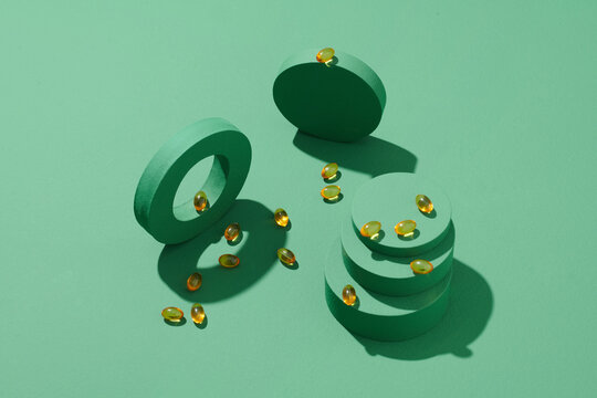 Soft yellow gelatin capsules oval shape on green background