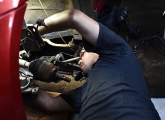 Mechanic replaces front axle parts