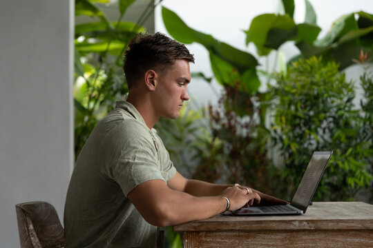Young man using laptop at home outdoors