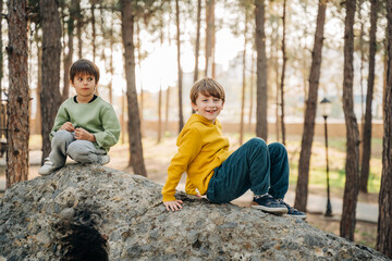School boys kids playing travel outside in the forest. Siblings brothers children taking a hike in the rocky boulder forest city park. © Anna