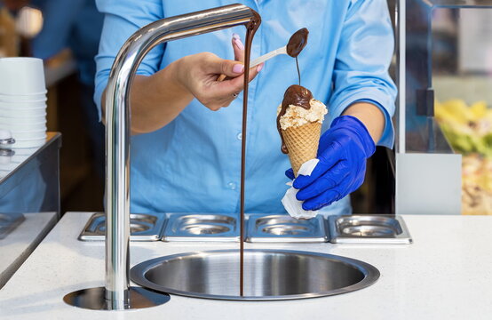 Serving ice cream with poured chocolate in the cake shop