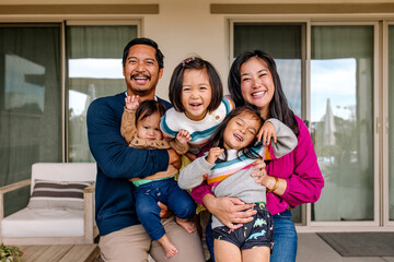 Authentic happy asian family portrait laughing and hugging together