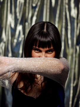 Woman with fun audacious expression covering her face