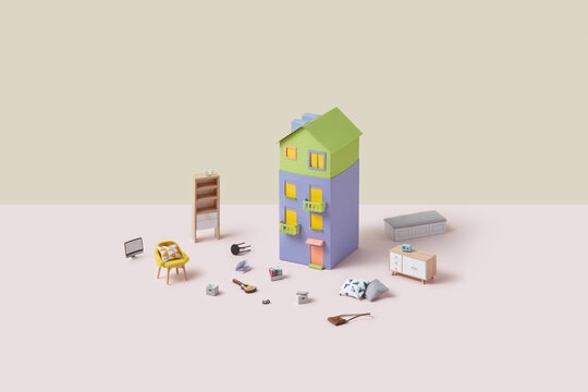 Miniature furniture and stuff elements around paper house.