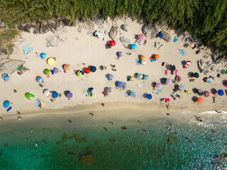 aerial view from the drone of Michelino beach near Tropea in Calabria. You notice the crystal clear Caribbean sea with bathers and umbrellas. the image gives a sense of peace and relaxation