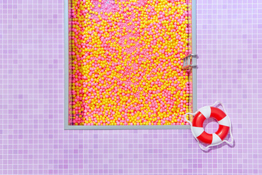 Swimming pool full of colorful balls with inflatable ring.