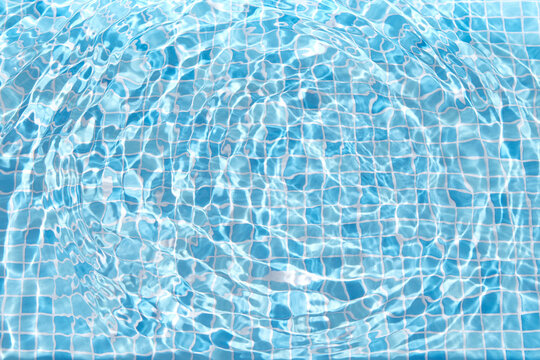 Simple blue-tiled swimming pool background with copy space.