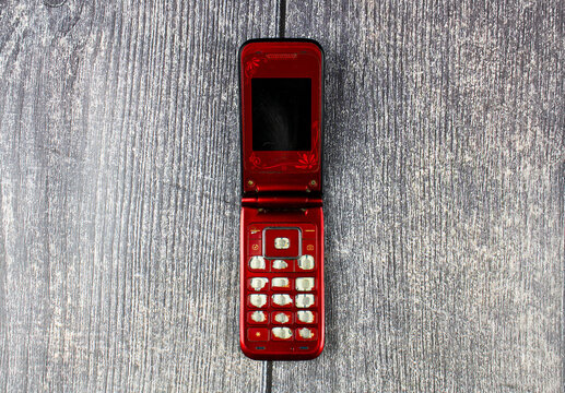 Classic mobile phone, flip.Retro folding cell phone. Old-fashioned push-button mobile wireless phone vintage.Folding phone with buttons. Old, dilapidated used phone, 2005-2010s.