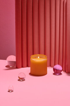 Flaming aroma candle in bowl on a blue-pink background with a shadow