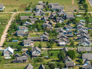 panoramic aerial view of eco village with wooden houses, gravel road, gardens and orchards