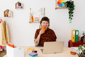 Cheerful non binary person laughing during remote work