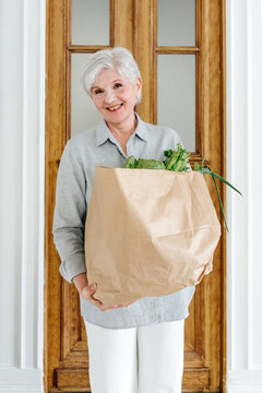 Portrait of senior woman with shopping paper bag 
