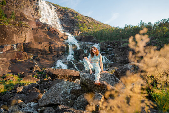 Woman near waterfall in mountains 