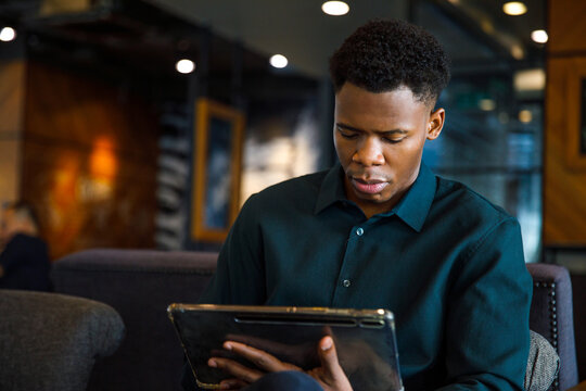 Black entrepreneur working on tablet in cafe