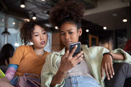 Bored teenagers looking at social media together